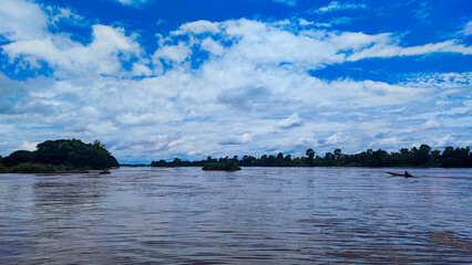 The traditional boat middle Mekong river with blue sky.