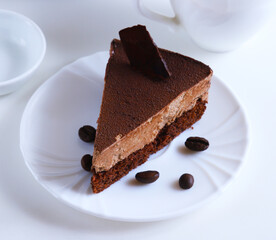 Part of a chocolate dessert cake on a plate in bright light. Shallow depth of field