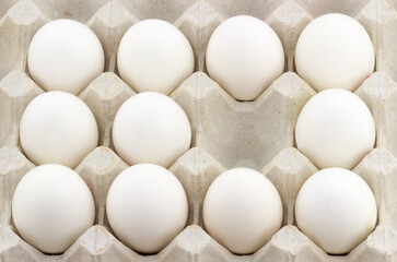 Close-up view of empty one position in the middle of white eggs in carton tray