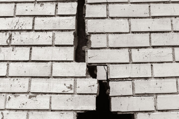Building Exterior Wall Cracked Damaged Closeup abstract background sepia black and white photograph.