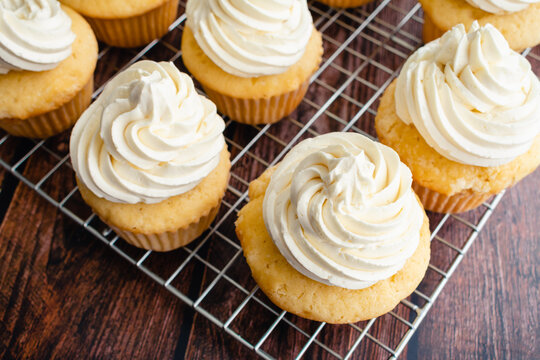 Homemade Vanilla Cupcakes on Wire Cooking Racks: Overhead view of vanilla cupcakes with vanilla buttercream frosting