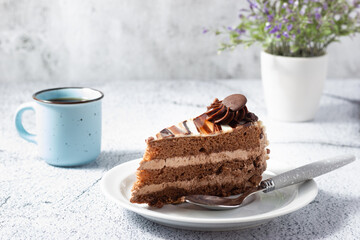 Delicious chocolate cake with fluffy cocoa sponge and marble effect icing with a cup of coffee.