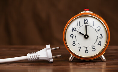 Electrical plug with an alarm clock. Energy saving, electricity, save power or energy crisis...