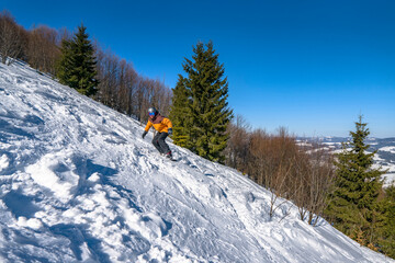 Snowboarder rides from snow hill. Mountain freeride snowboarding. Winter mountains Carpathians