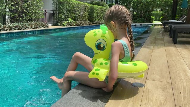 Little girl has fun, swims and dives in the pool