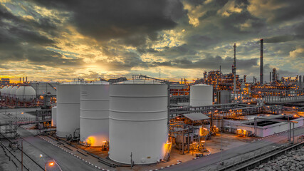 Petrochemical storage tank with oil refinery background, Oil refinery plant at night, Oil and gas industry refinery, Petrochemical plant at twilight. - obrazy, fototapety, plakaty