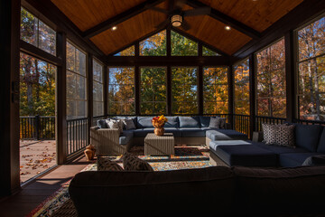 Cozy screened porch enclosure with contemporary furniture at Thanksgiving Holiday. Porch door open,...