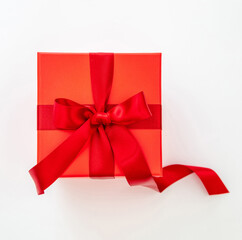 Red gift box with red passion ribbon isolated cutout on white background, top view.