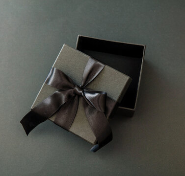 Black Friday sale concept, Gift box open with ribbon, black background, overhead.