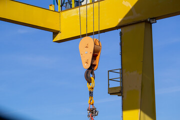 gantry crane with hook against blue sky. an overhead crane on a construction site or in a production hall	