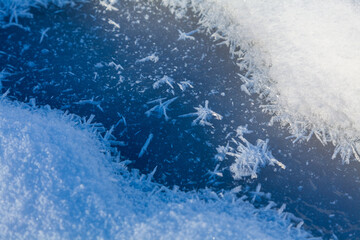 Close-up snow crystals on icy surface.