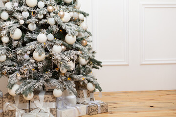 White decorated Christmas tree against white wall copy space