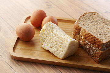 Close up of cheese, milk , brown bread and almond nut on table.