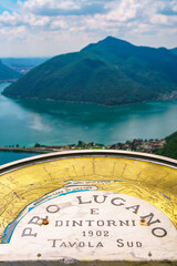 Stunning landscape of picturesque Lake Lugano and the green lush Swiss Alps in the distance. Idyllic town Lugano, Switzerland,  on a sunny summer day.