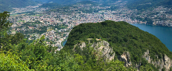 Spectacular panoramic view over the city of Lugano, the Lugano Lake and Swiss Alps, visible from Monte San Salvatore observation terrace, canton of Ticino, Switzerland.