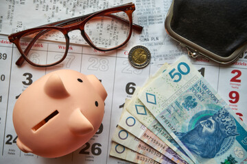 paragony fiskalne ,polskie banknoty , polska moneta, kartka z kalendarza, świnka skarbonka, emerytura 