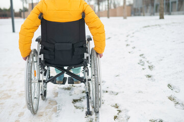 Cropped frame of a woman in a wheelchair in winter. 
