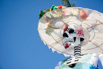 Huge skull and crossbones with regional Mexican dress for traditional Day of the Dead festivities called Catrina