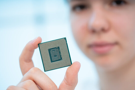 girl holds a processor made using 5 nanometer technology in her hands