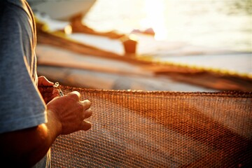 Fisherman repairing a fishing net