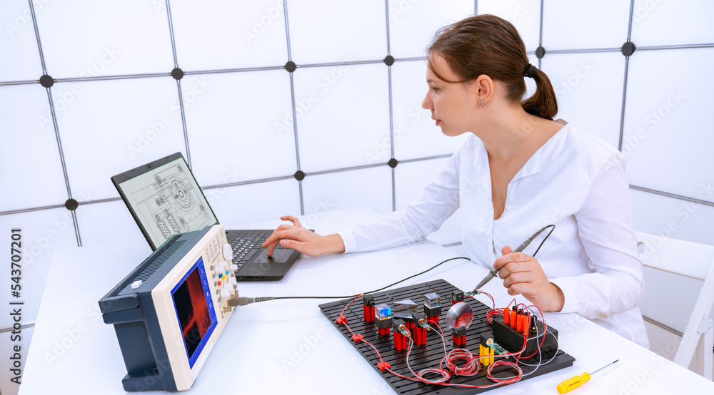 Poster young woman student is experimenting with a laser measurement system for the optical properties of substances in a physics laboratory