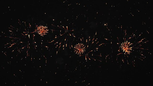Fireworks bright golden fiery flashes on the black night sky. Overall plan