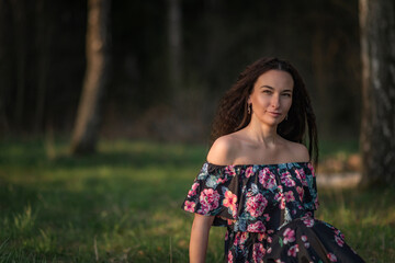 Fototapeta premium Portrait of a young beautiful dark-haired girl in nature.