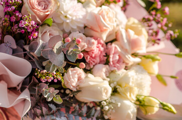Wonderful pink bouquet with different flowers and leaves under the rays of the sun, beautiful background for a card