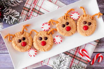 Christmas peanut butter red nose reindeer cookies. Top down view table scene over a rustic wood...