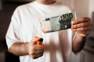 100 euro banknote burns from the fire of a lighter. The concept of cost for natural gas. Energy...