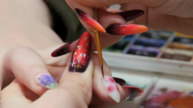 Applying a floral pattern to the nail.