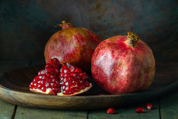 pomegranate seeds fruit Fresh ripe wooden  background open dark vintage background still life organic Red vitamins wooden plate table closeup sweet.