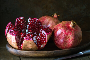 pomegranate seeds fruit Fresh ripe wooden  background open dark vintage background still life organic Red vitamins wooden plate table closeup sweet.
