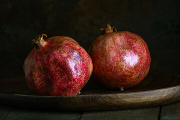 pomegranate seeds fruit Fresh ripe wooden  background open dark vintage background still life organic Red vitamins wooden plate table closeup sweet.