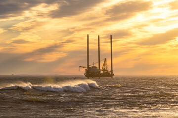 A jack up barge doing geotechnical survey work off the coast of long island in preparation for wind farm - Long Beach New York - obrazy, fototapety, plakaty