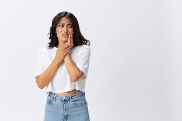 Woman toothache and sadness, inflammation of the teeth, a cold in a white t-shirt on a white background