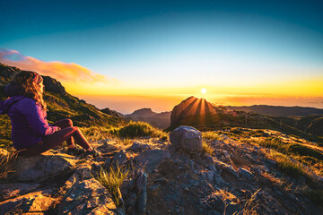 Sitting woman watching the sunrise over the beautiful mountain landscape of Pico do Ariero. Pico do...