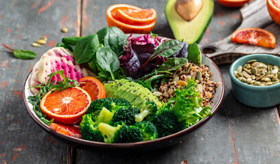 Vegan, detox Buddha bowl with vegetables, avocado, blood orange, broccoli, watermelon radish,...