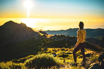 Woman enjoying beautiful mountain landscape of Pico do Ariero during sunrise. Pico do Arieiro,...