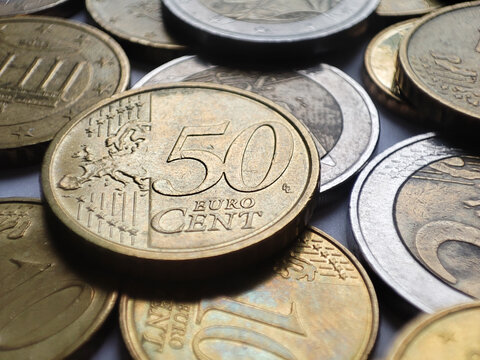 Fifty euro cents close up detail with many euro coins around it, money background, savings in financial crisis