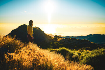 Woman enjoying beautiful mountain landscape of Pico do Ariero during sunrise. Pico do Arieiro,...
