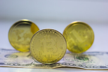Three cryptocurrency coins on a dollar bill close-up