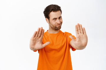 Portrait of brunette man say stop, prohibit smth, stretching out hand to forbid smth, standing over...