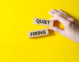 Quiet firing symbol. Concept word Quiet firing on wooden blocks. Businessman hand. Beautiful yellow background. Business and Quiet firing concept. Copy space