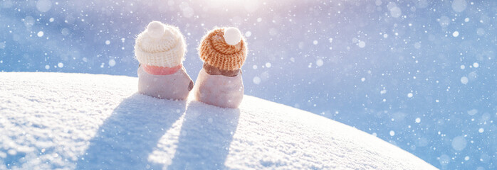 christmas card. Statuette figurine of two snowmen beanie on a snowy background outdoors.