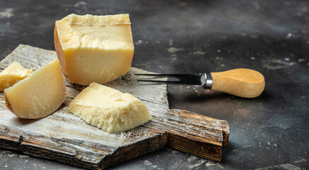 gruyere cheese, a traditional Swiss hard yellow cheese without holes, with a dark crust and a...