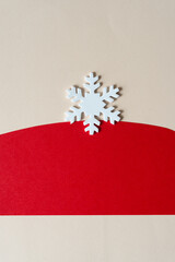 simple white foam snowflake and red paper shape on beige