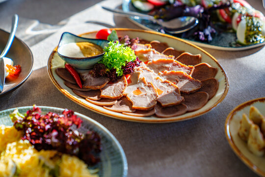 salads and cold cuts. a table served with utensils and snacks for lunch.