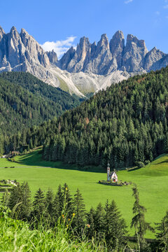 Ranui Church St Johnann with the Dolomites mountains Geisler Group in the background in Val di Funes, South Tyrol, Italy