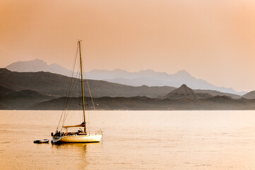 France. Corsica. Cap Corse. Sailboat anchored in the Bay of Nonza at sunset
